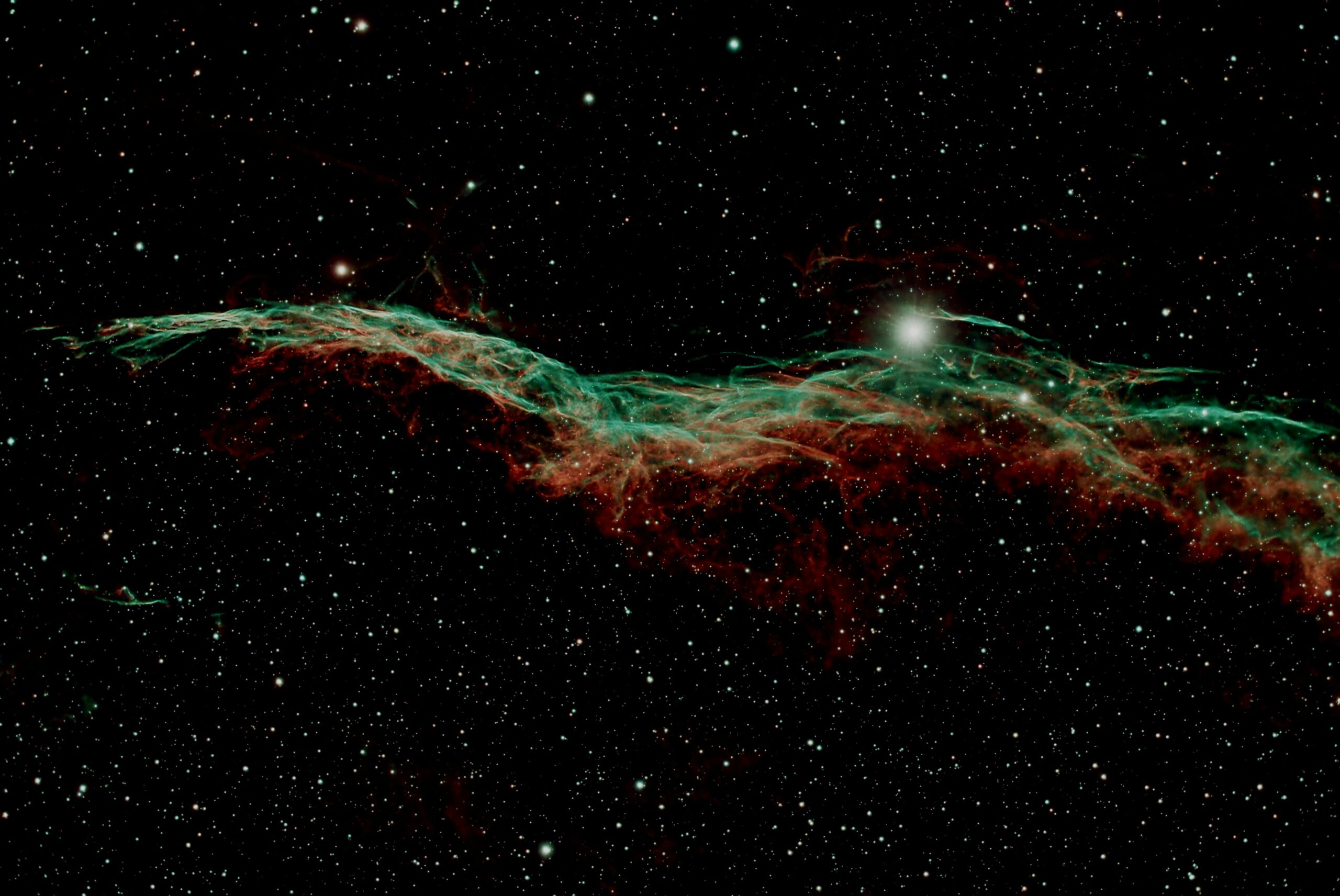 Captivating view of the Veil Nebula glowing amidst distant stars in deep space.